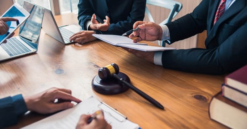 66cbc84cccc953215a154d82_Lawyers-sitting-at-a-table-dicussing-a-case